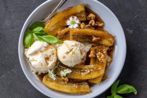 Classic Bananas Foster in a serving plate with ice cream.