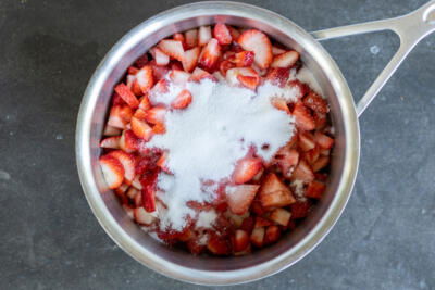 Strawberries and sugar in a pan.