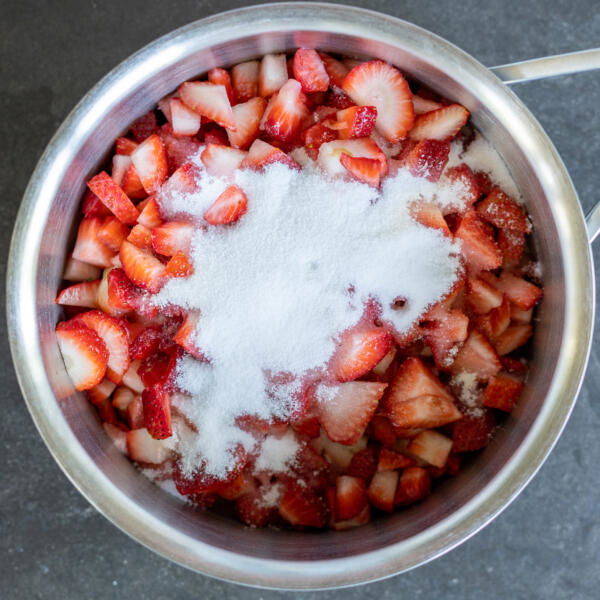 Strawberries and sugar in a pan.