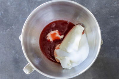 Strawberry sauce, cream cheese and sugar in a blender bowl.