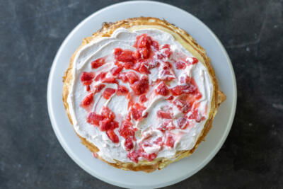 Crepe, cream and strawberry sauce on top.