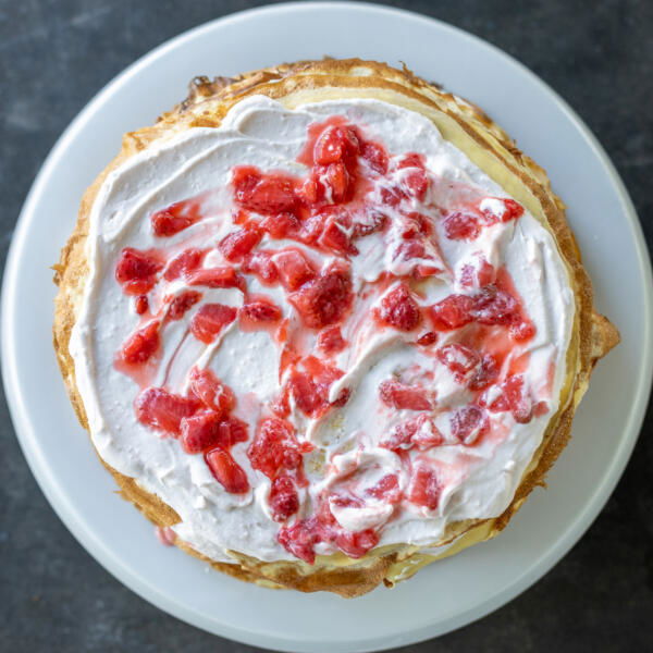 Crepe, cream and strawberry sauce on top.