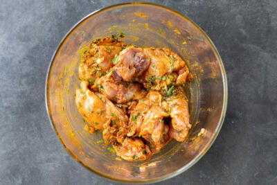 Chicken marinating in a bowl.