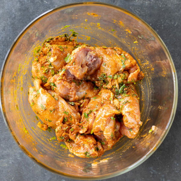 Chicken marinating in a bowl.