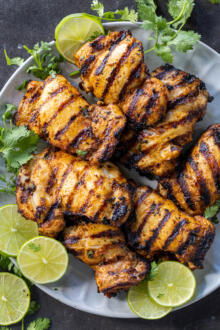Cilantro Lime Chicken on a plate with lime and cilantro.