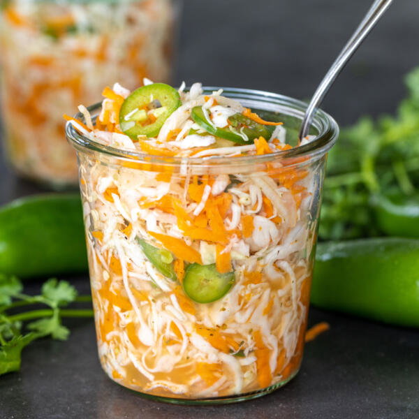Jar with Curtido and herbs.