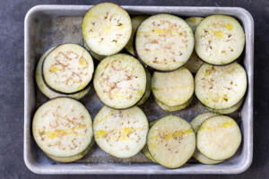 Seasoned eggplant on a baking sheet.