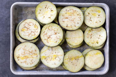 Seasoned eggplant on a baking sheet.