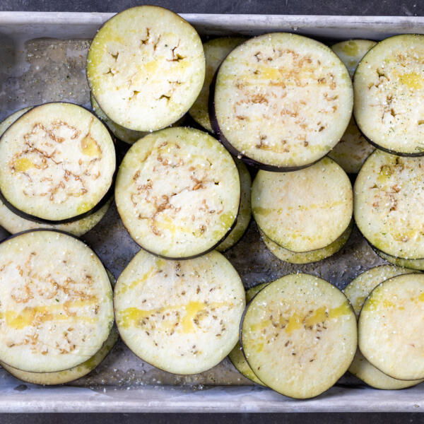 Seasoned eggplant on a baking sheet.