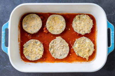 Marinara and crusted eggplant in a baking pan.