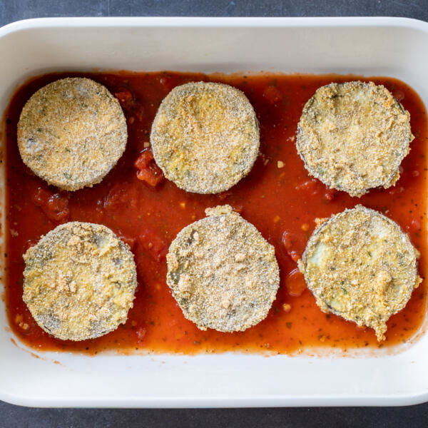 Marinara and crusted eggplant in a baking pan.