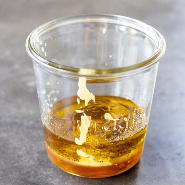 A jar with all the ingredients for Honey Dijon Dressing.