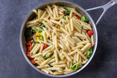 Pasta in a pan with veggies.