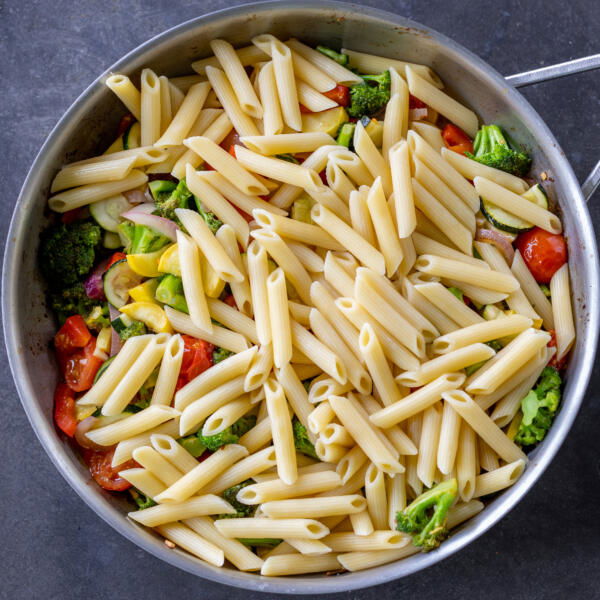 Pasta in a pan with veggies.