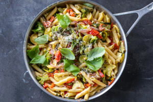Cheese and basil added to pasta with veggies.