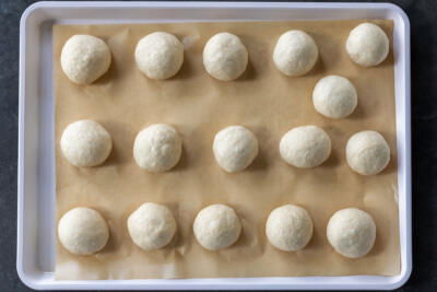 Dough divided into pieces on a baking sheet.