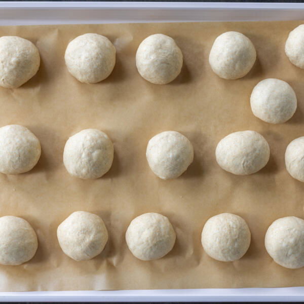 Dough divided into pieces on a baking sheet.