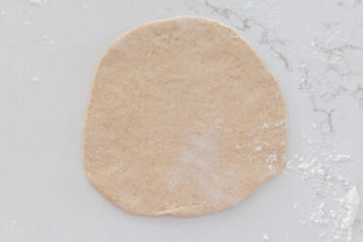 Rolled out pita on a counter.
