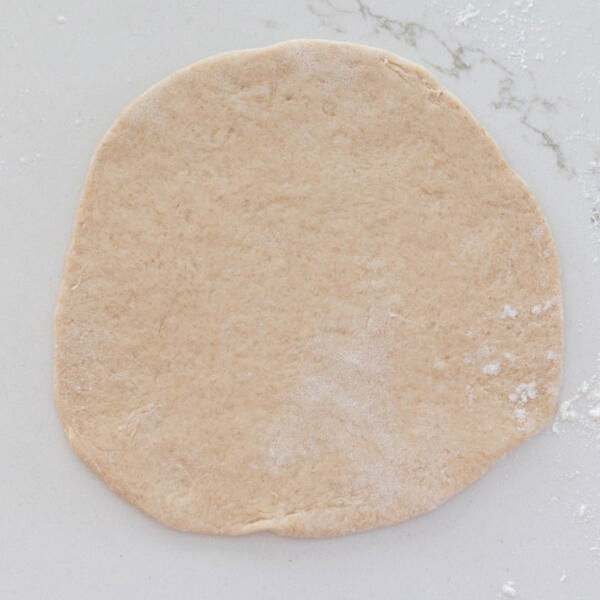Rolled out pita on a counter.
