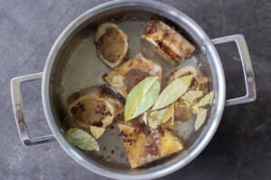 Bones, water bay leaves in a pot.