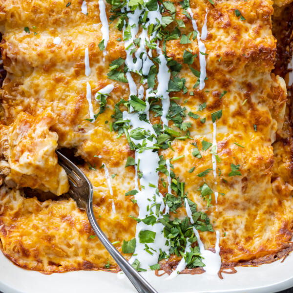 Baked Chicken Enchiladas with a fork inside of it.