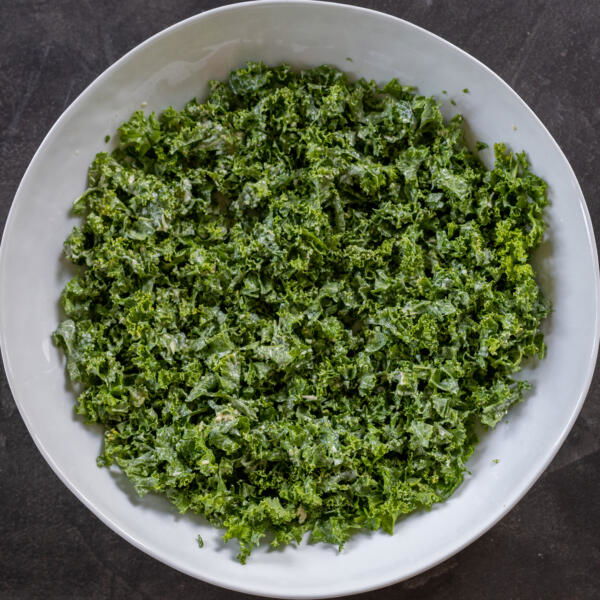 Kale with caesar dressing in a bowl.