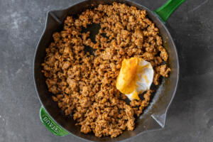 Chorizo cooking in a skillet.