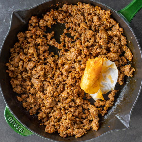 Chorizo cooking in a skillet.