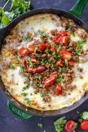 Queso Fundido with herbs and tomatoes.