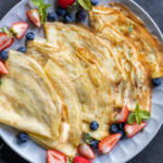 Plated Sourdough Crepes with berries around.
