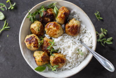 Turkey Zucchini Meatballs in a bowl with rice and herbs.