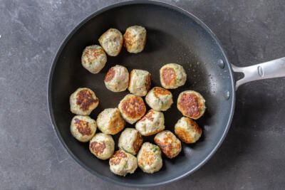 Turkey Zucchini Meatballs on a frying pan.