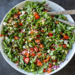 Mediterranean Farro Salad in a serving bowl with utensils.