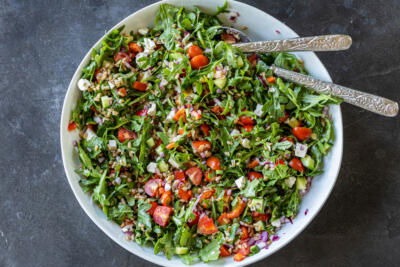 Mediterranean Farro Salad in a serving bowl with utensils.