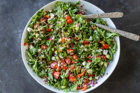 Mediterranean Farro Salad in a serving bowl with utensils.