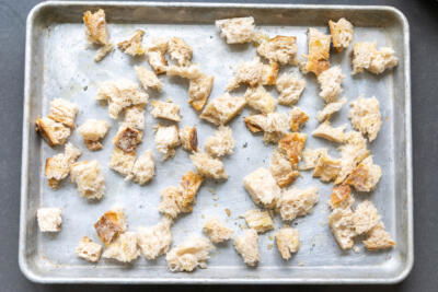 Ripped up bread on a baking sheet.