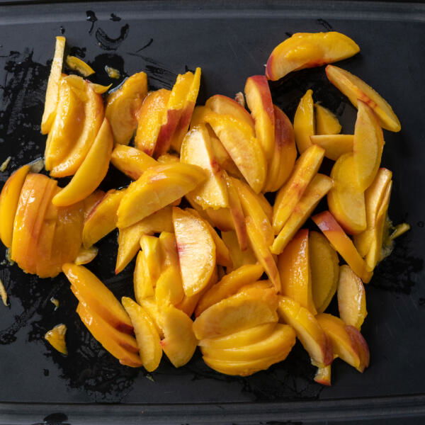 Peach slices on a cutting board.