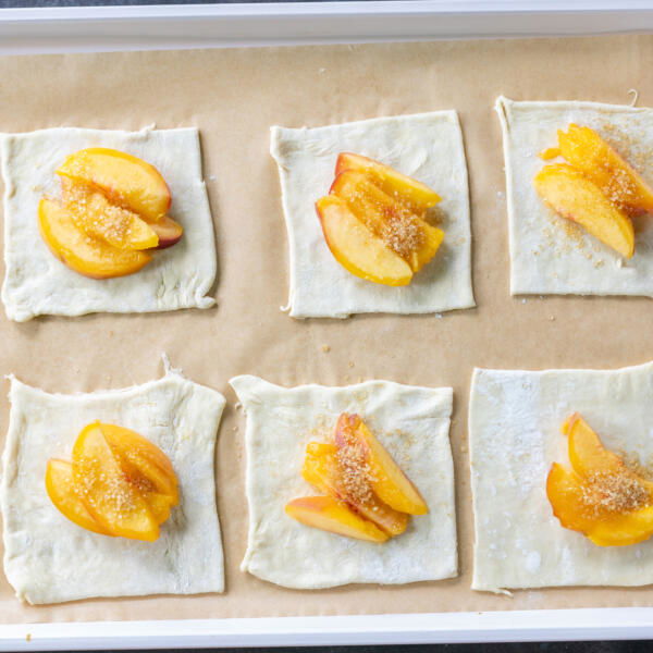 Puff pastry dough with pieces of peaches.
