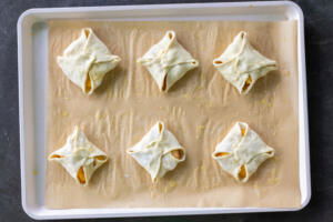 Peach Turnovers on a baking sheet prior to eggs and sugar.