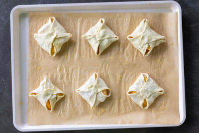 Peach Turnovers on a baking sheet prior to eggs and sugar.