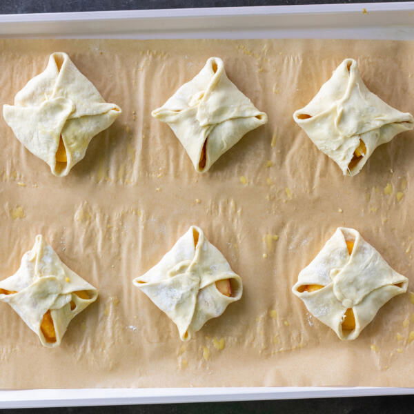 Peach Turnovers on a baking sheet prior to eggs and sugar.