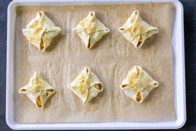 Peach Turnovers on a baking sheet prior to baking.
