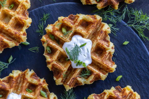 Crispy Mashed Potato Waffles with sour cream and herbs.