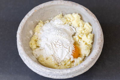 Mashed potatoes with flour and egg in a bowl.