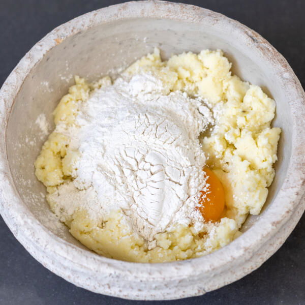 Mashed potatoes with flour and egg in a bowl.