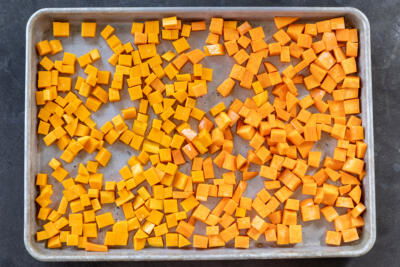 Sweet potatoes and butternut squash on. baking sheet.