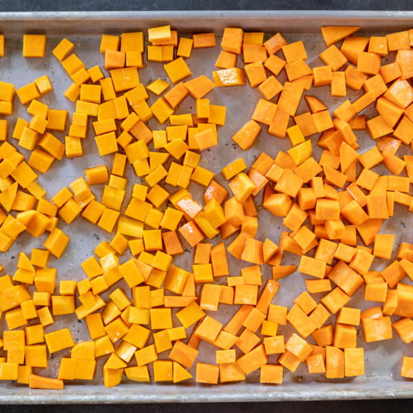 Sweet potatoes and butternut squash on. baking sheet.