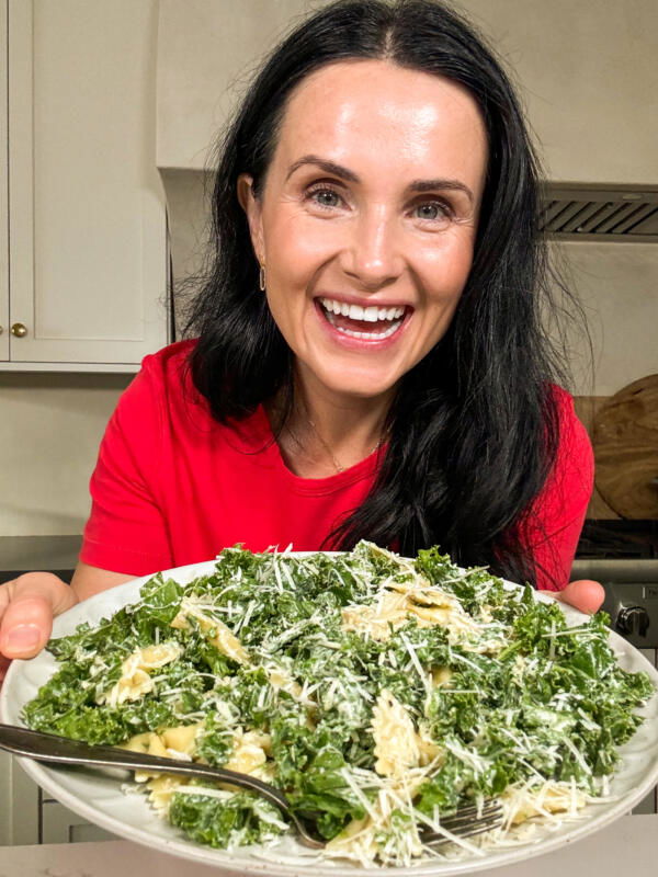 Natalya with a plate of Pasta kale caesar salad. 