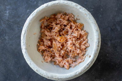 Crumbled smoked salmon in a bowl.