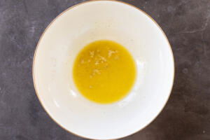Melted butter with garlic and seasoning in a bowl.